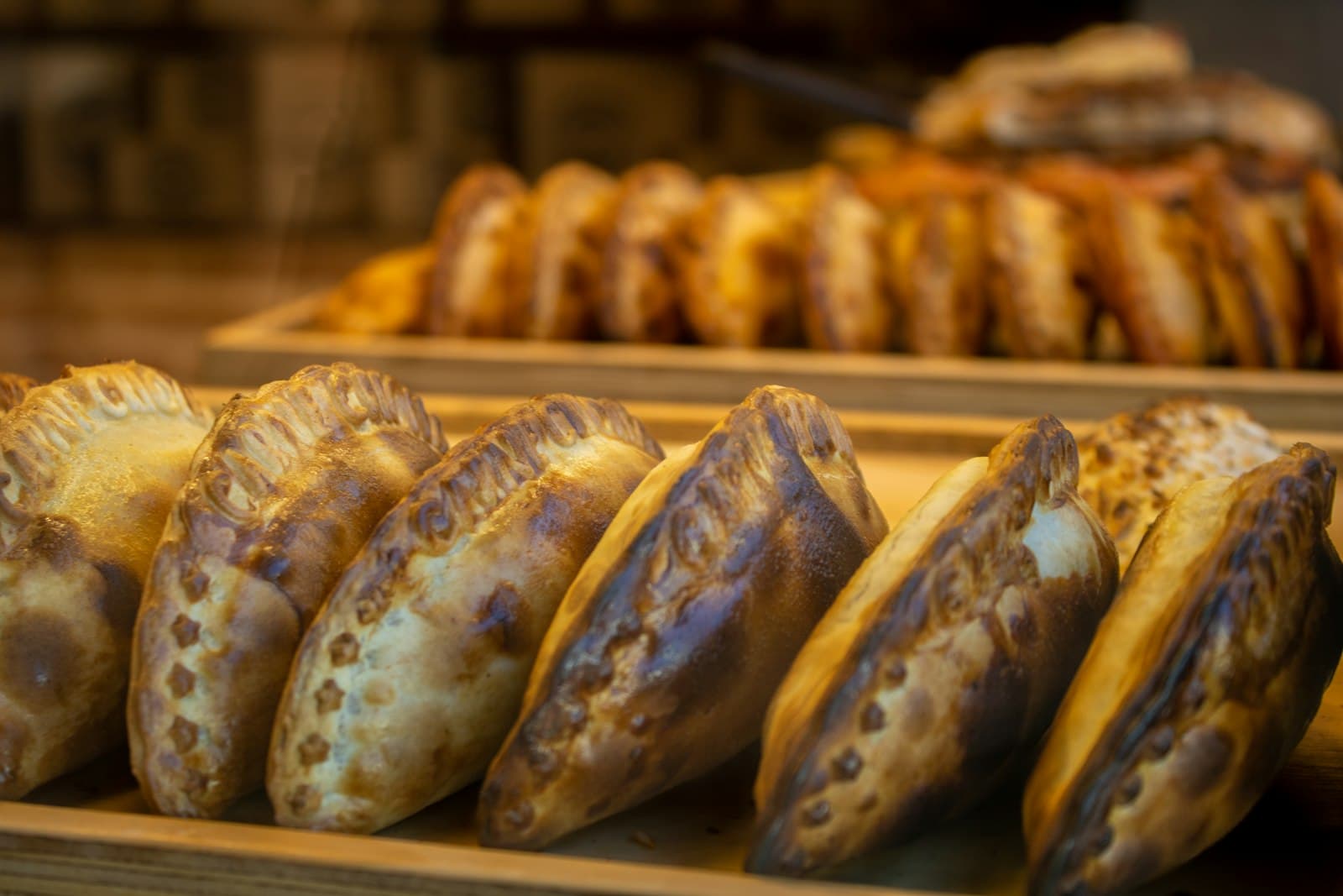 Empanadas lined up in a bakery case