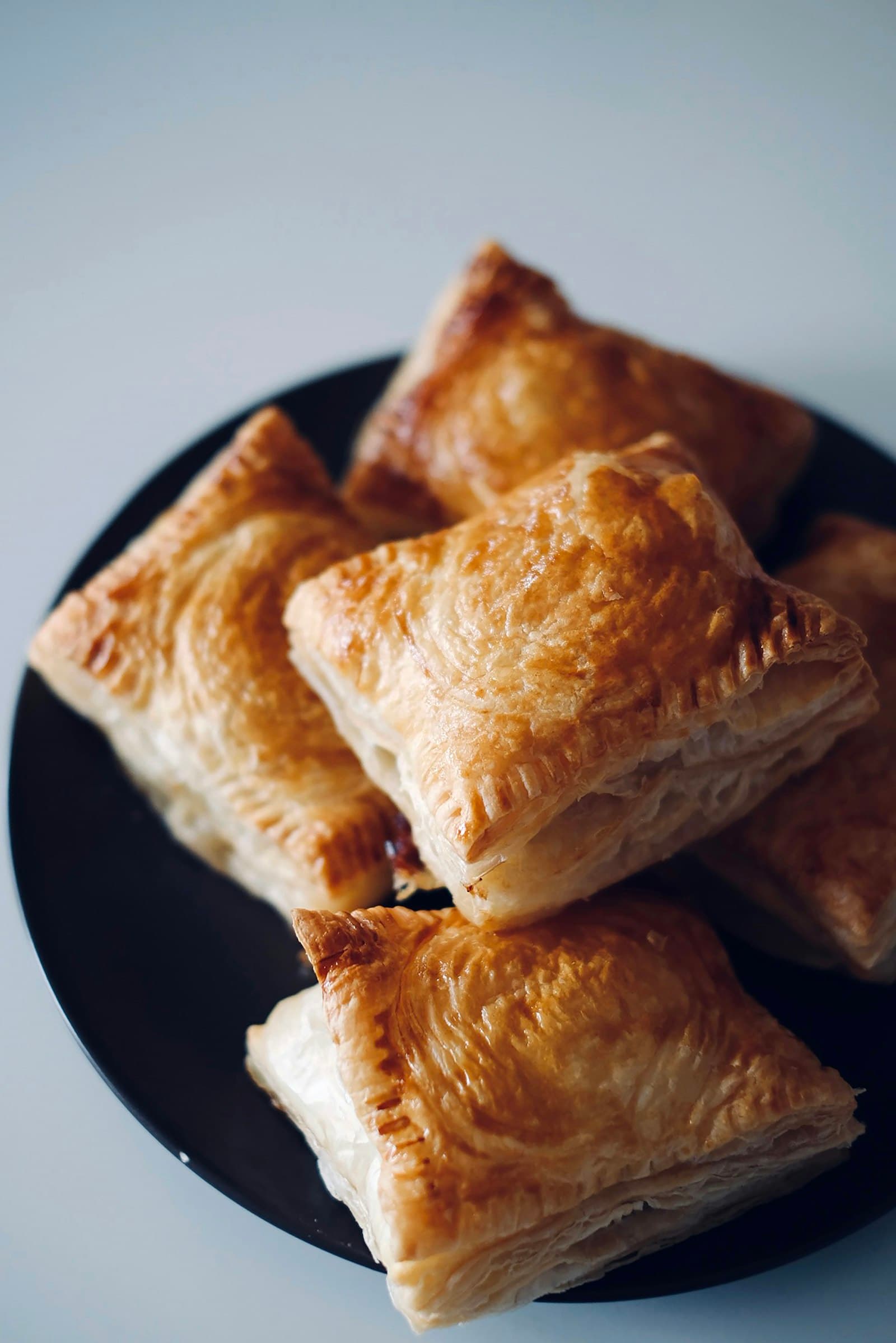 Squares of puff pastry on a black plate
