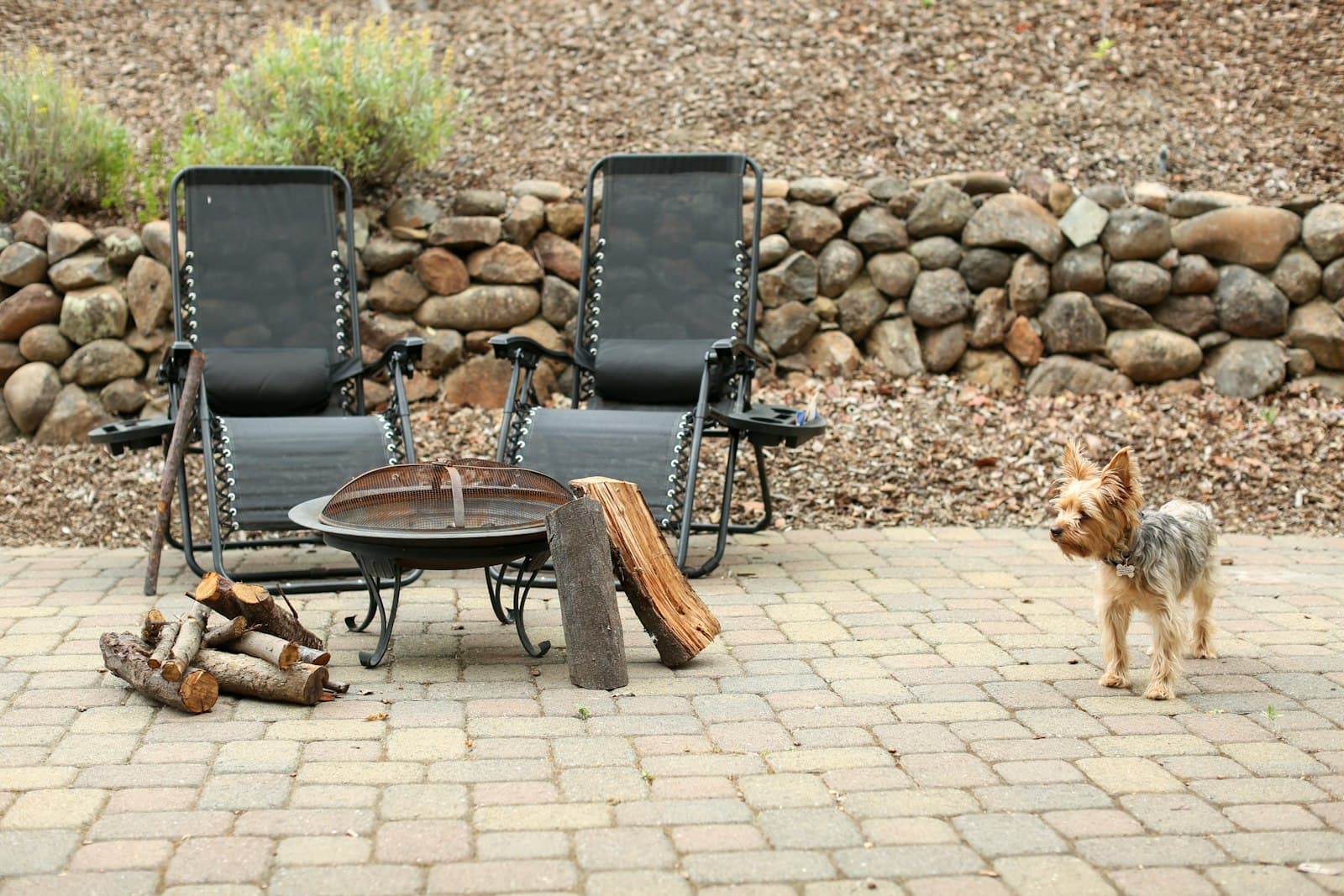 A paved patio with seating and a fire bowl