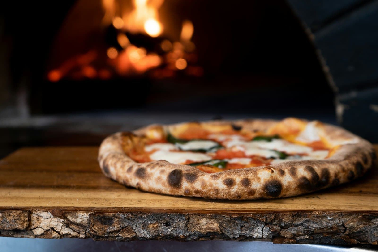 Pizza in front of a wood-fired oven