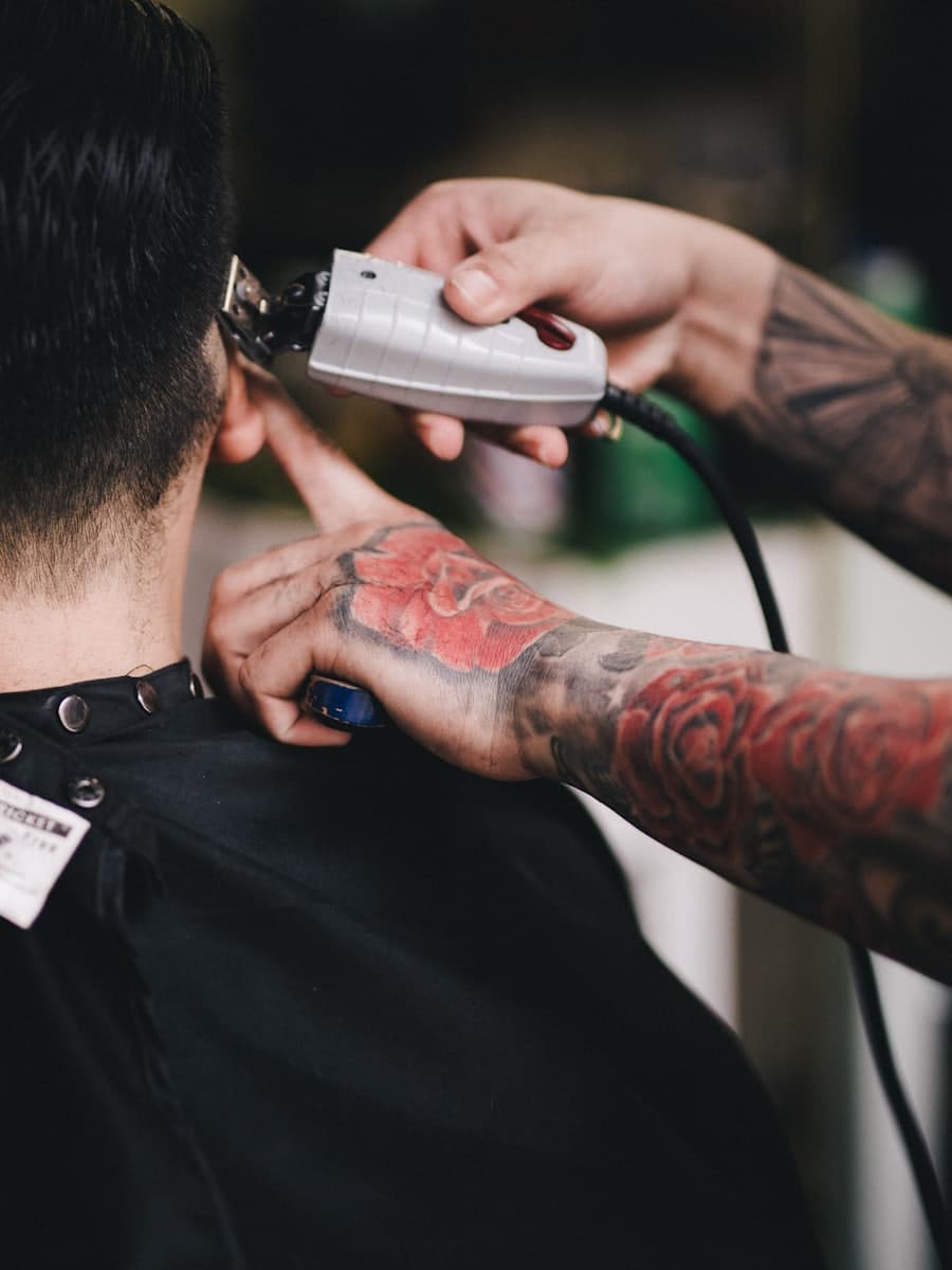 Barber working a fade with clippers, seen from behind