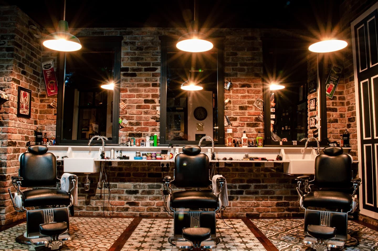 Fadeline shop floor — three vintage barber chairs against a brick wall under pendant lamps