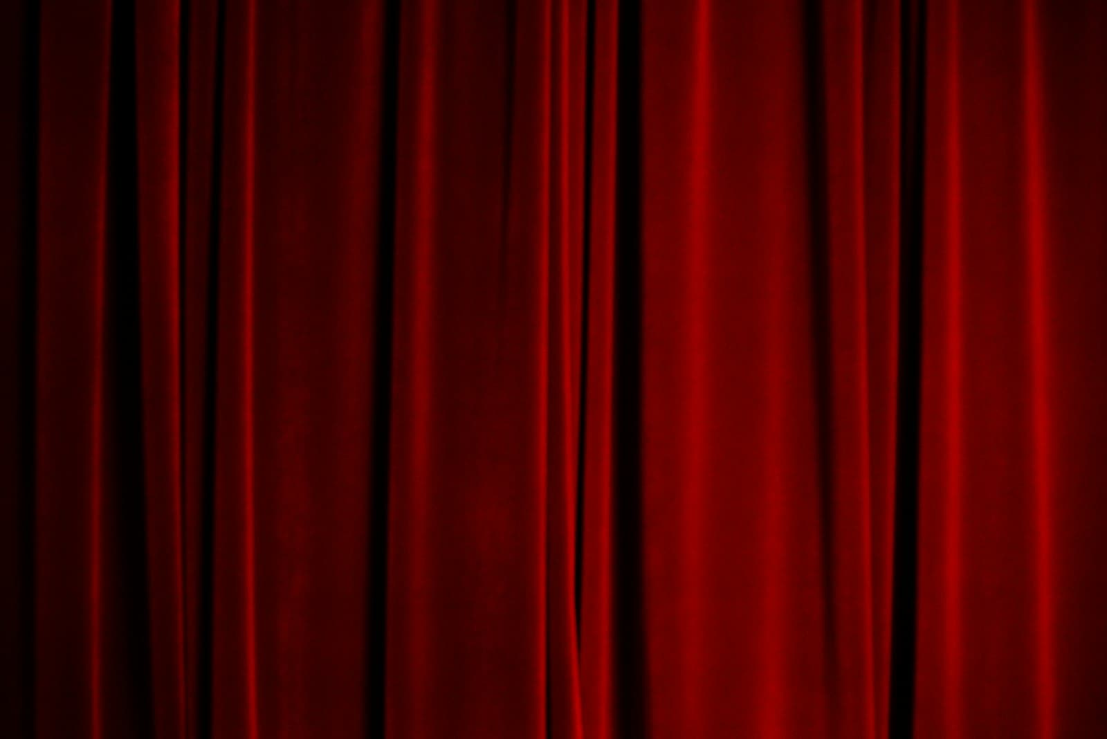 Deep red velvet stage curtain catching low light