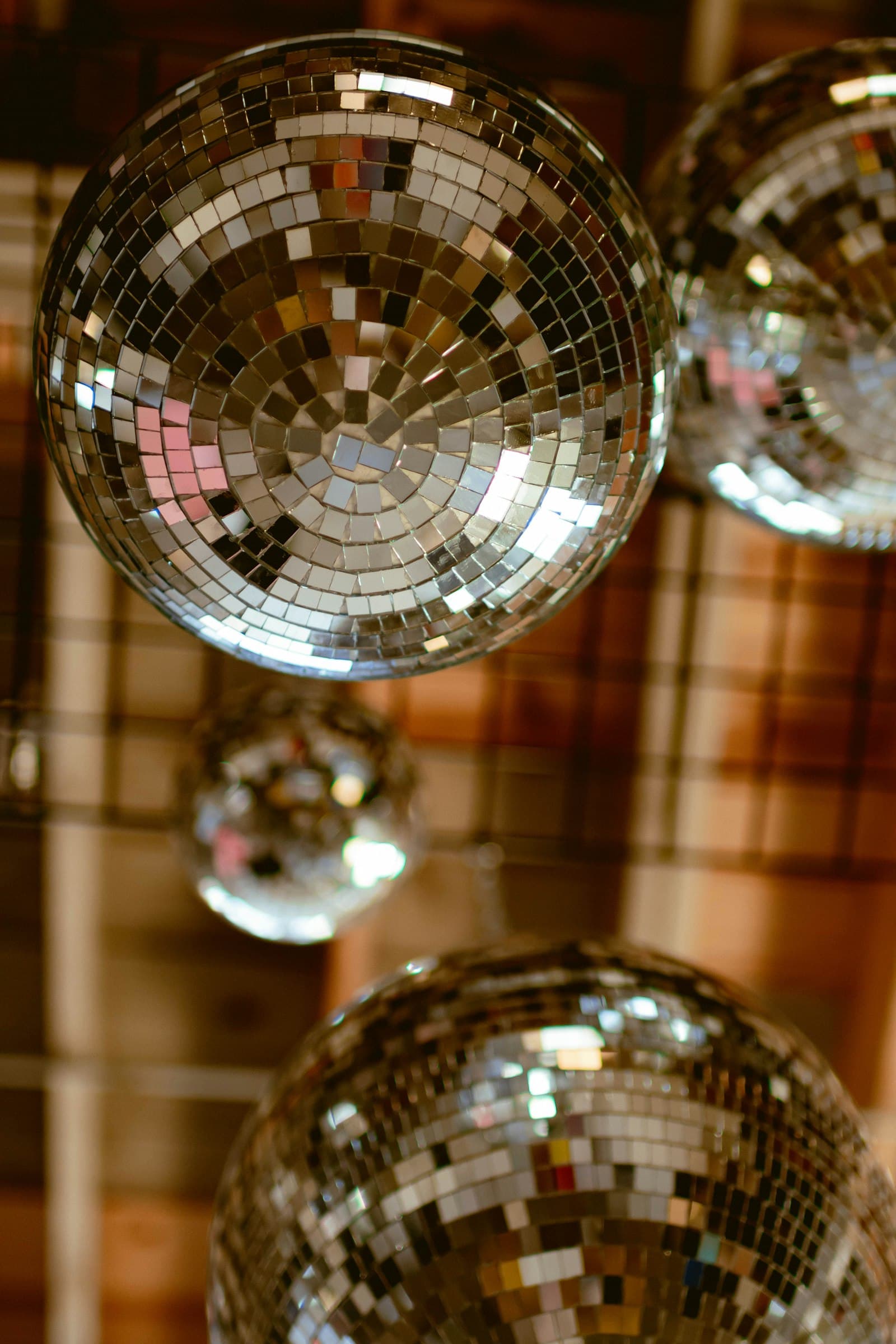 Cluster of mirror balls hanging from a warm-lit ceiling