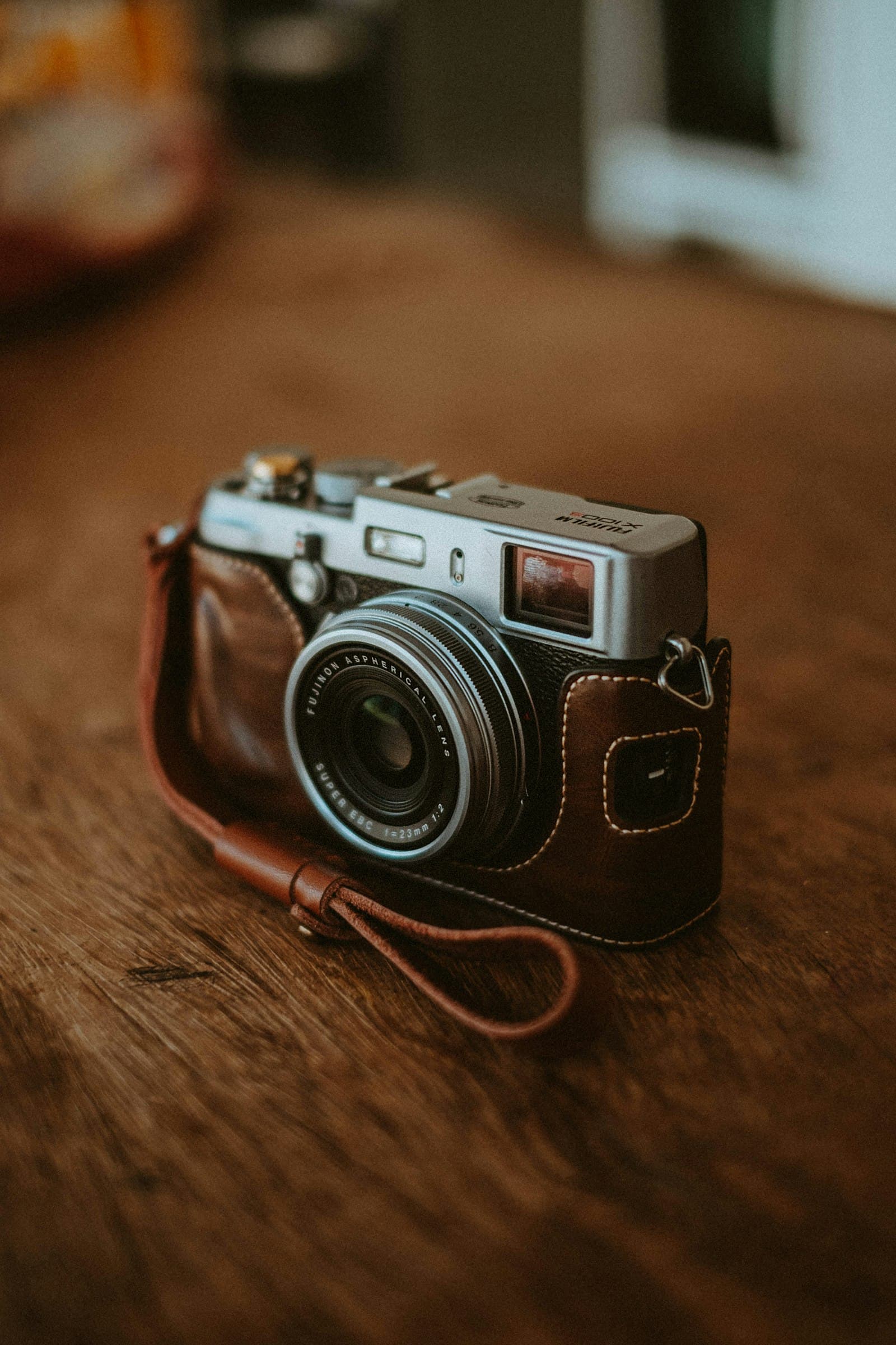 A film camera resting on a wooden table